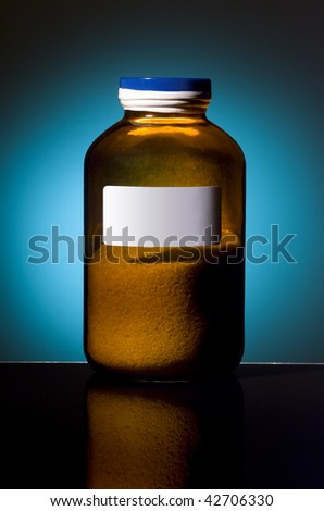 Amber glass bottle with pharmaceutical product inside on cyan with white label