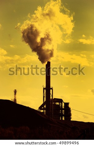 Factory smoke stack emitting toxic fumes in yellow green atmosphere