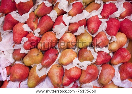 Red pears in wrapping paper on farmers fruit stand