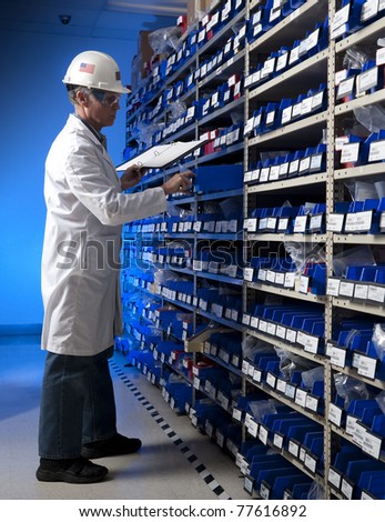Factory Worker taking inventory in stock room of a manufacturing company