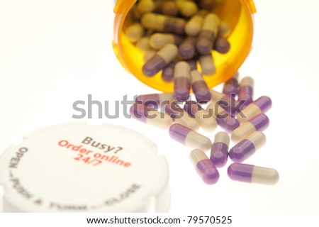 Pills spilling from bottle on the white