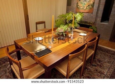 Modern dining room table in rich woods set for a sumptuous meal