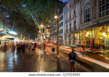 BARCELONA, SPAIN - JULY 31: Crowded La Rambla street at the heart of Barcelona, Spain at night time with the Liceu Theater on the right on July 31, 2013.