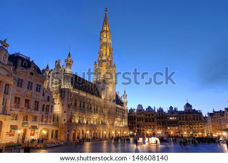 Wide angle night scene of the Grand Place, the focal point of Brussels, Belgium. The Town Hall (Hotel de Ville) is dominating the composition with its 96m tall spire.