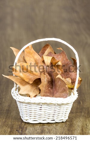 Studio shot of a wicker hamper full with dead autumn leaves