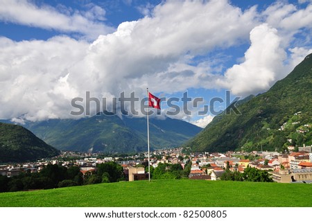 Swiss flag over beautiful town Bellinzona in alpine valley, Switzerland