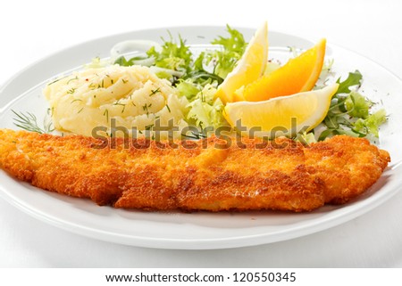 Fish dish - fried fish fillet with vegetables on white background