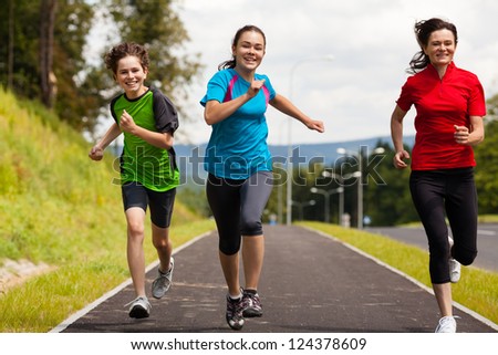 Active family - mother and kids running, jumping outdoor