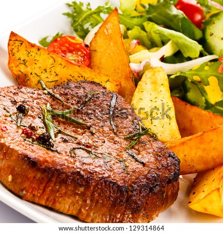Grilled steaks, baked potatoes and vegetable salad
