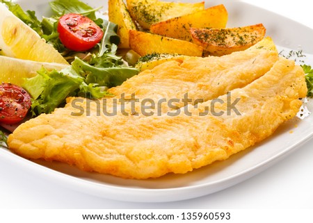 Fish dish - fried fish fillet with baked potatoes and vegetables