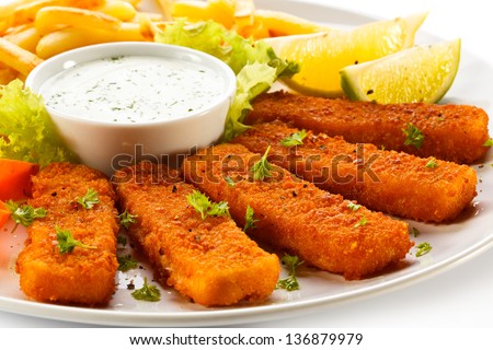 Fried fish fingers, French fries and vegetables