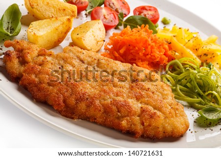 Fried pork chops, baked potatoes and vegetable salad