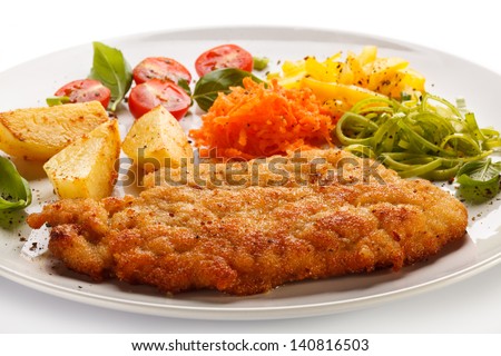 Fried pork chops, baked potatoes and vegetable salad