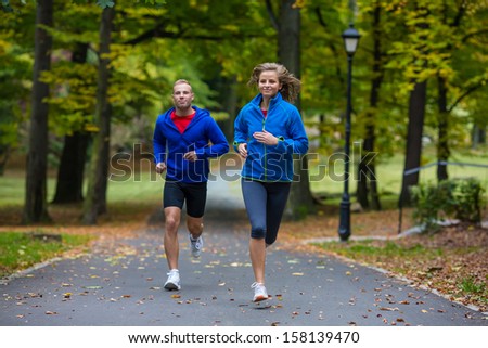 Young Woman And Man Running In Park
