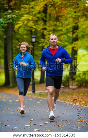 Young woman and man running in park