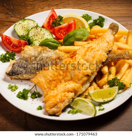 Fish dish - fried fish fillet, French fries with vegetables