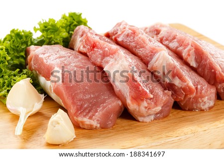 Fresh raw pork chops on white cutting board