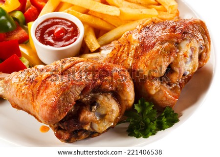 Grilled turkey legs with French fries and vegetables