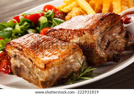 Grilled pork ribs, chips and vegetables