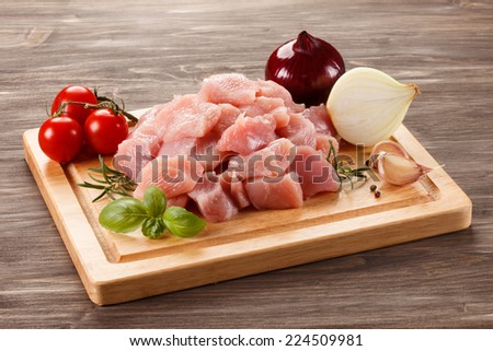Raw turkey meat on cutting board on wooden background