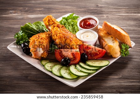 Fried chicken drumsticks and vegetables