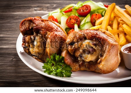 Grilled turkey legs with chips and vegetables