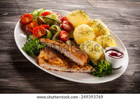 Fried pork chops, boiled potatoes and vegetable salad