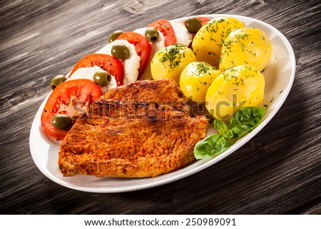 Fried pork chops, boiled potatoes and caprese salad