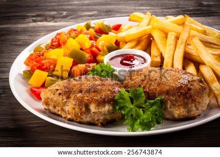 Fried chops, French fries and vegetable salad