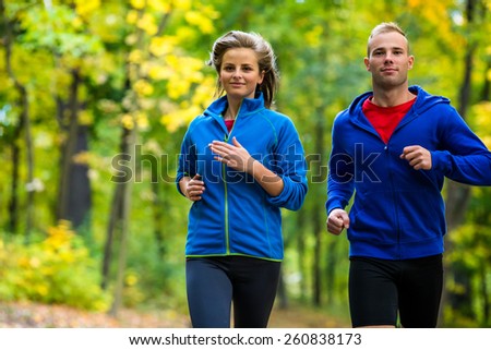 Healthy lifestyle - woman and man running in park