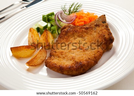 Fried chop pork, chips and vegetable salad