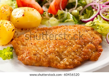 Fried pork chop with potatoes and vegetable salad