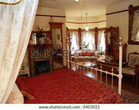 Antique bedroom decoration with brass bed and sitting area.