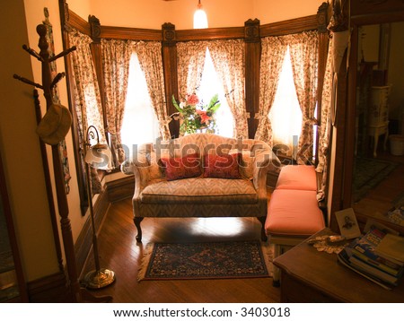 Antique furniture displayed in a sitting area of a bedroom.  Victorian style.