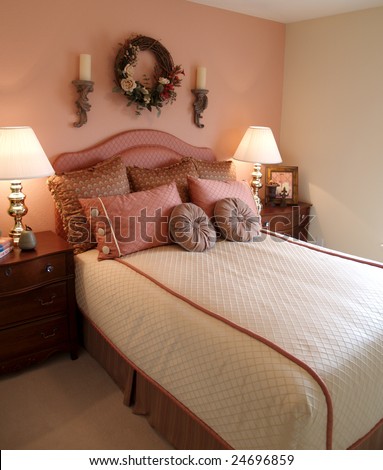 Bedroom with pink accent wall focus on bed and bedding