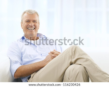 Portrait of a happy senior man sitting on couch