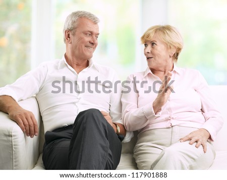 Close-up portrait of senior couple sitting on couch and talking
