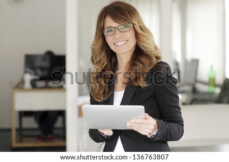 Portrait of a cute confident business woman with digital tablet in office