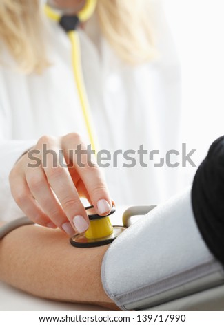 Close-up of Doctor/nurse checking blood pressure with stethoscope