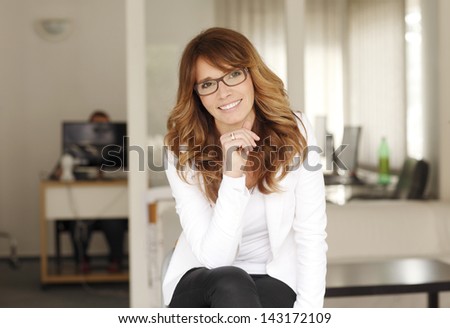 Mature smiling businesswoman sitting in her office