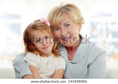 Smiling grandmother embracing her granddaughter