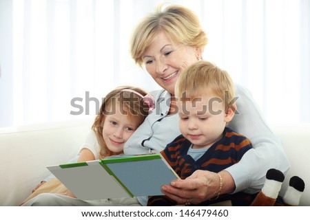 Grandmother reading from a book for grandchildren at home