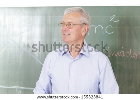 Teacher standing in front of blackboard in the classroom