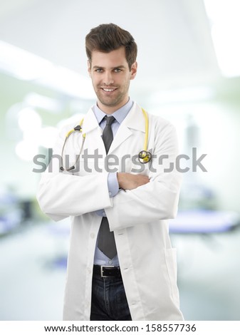 Portrait of happy young  medical doctor standing in hospital