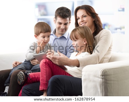 Happy young family sitting on sofa in living room