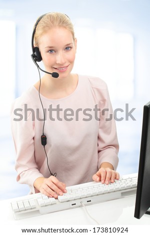 Beautiful customer representative with headset smiling during a telephone conversation.