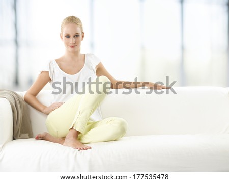 Beautiful young woman relaxed on sofa in living room.