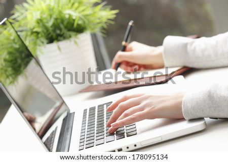 Close-up of businesswoman\'s hands doing paperwork.