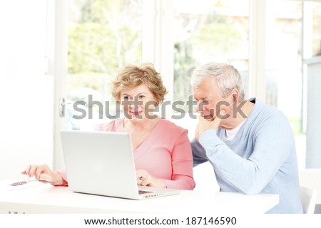 Happy senior couple planning for retirement at home.