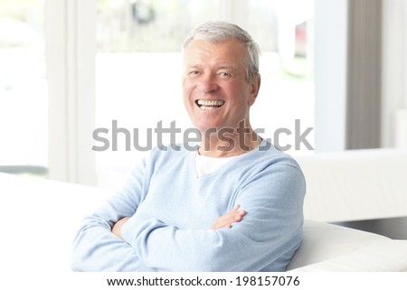 Portrait of active senior businessman sitting at sofa.  Small business.